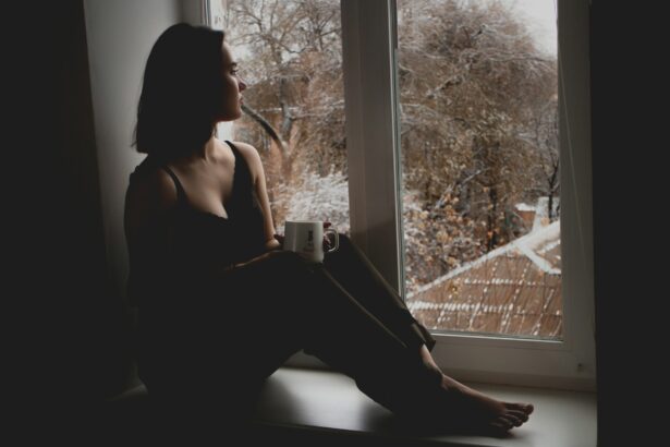 person sitting window rain looking out thoughtful