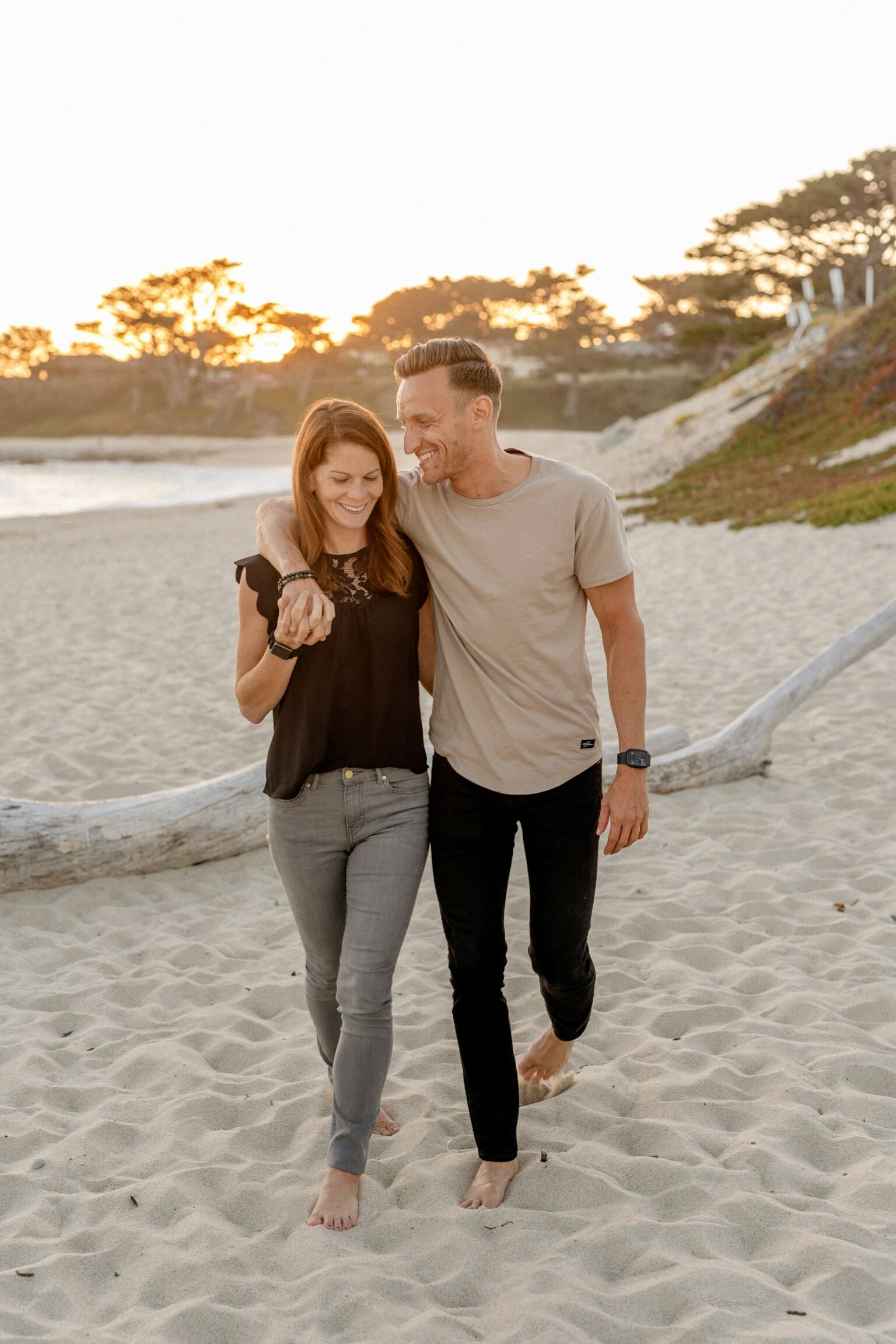 happy mature couple walking beach laughing