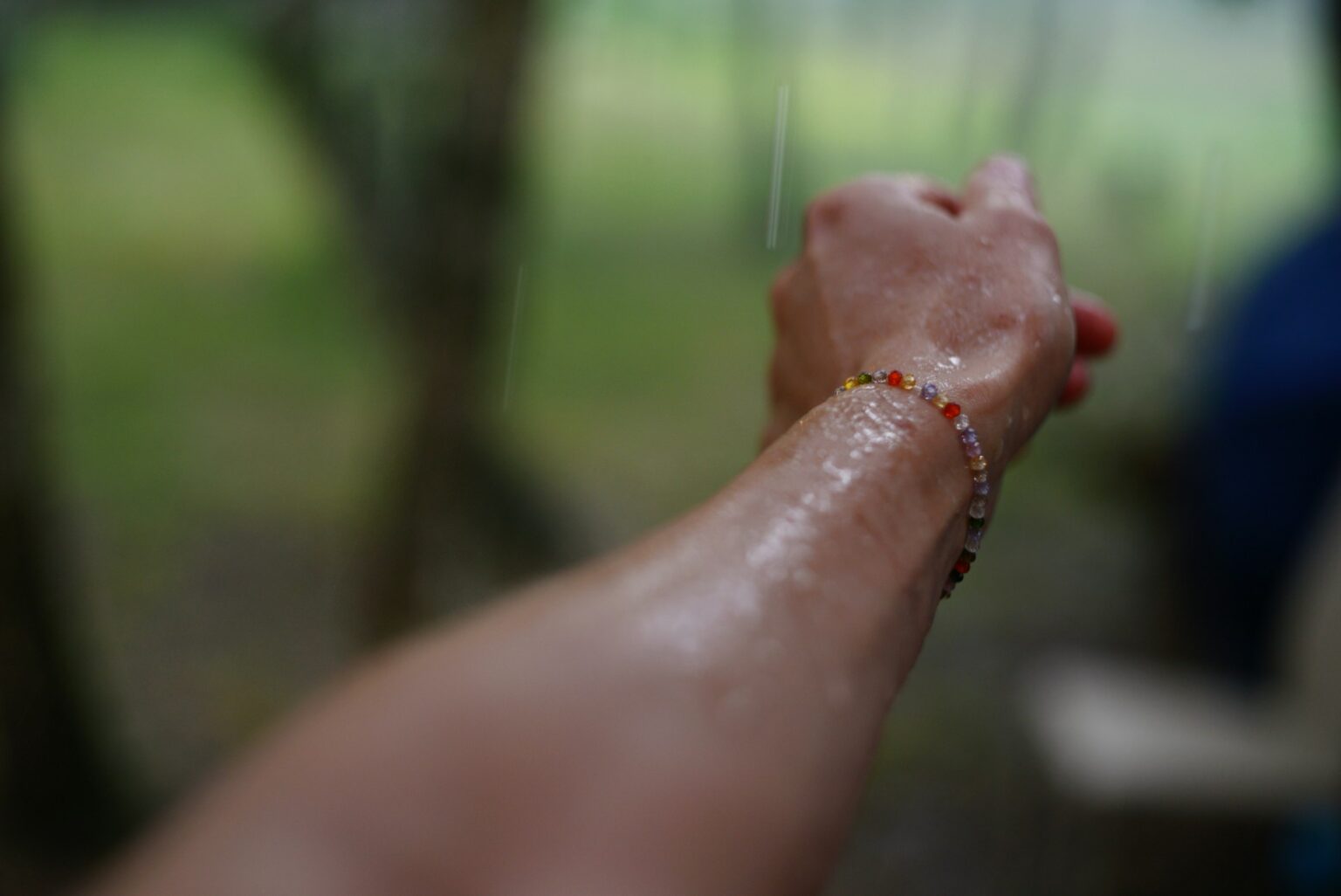 person hand touching glass pane rain outdoors