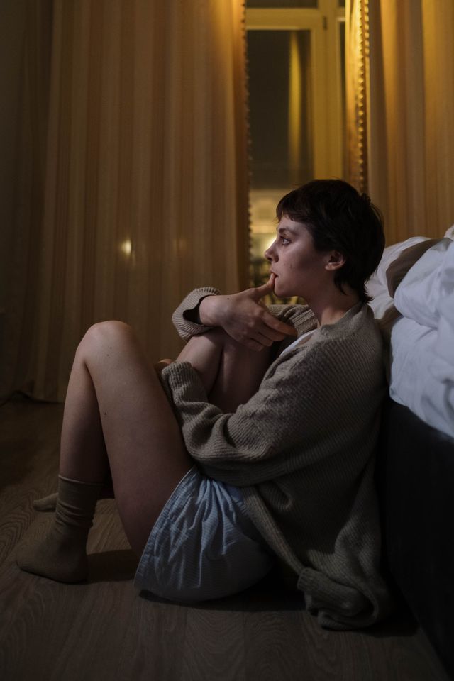 thoughtful person sitting home alone interior