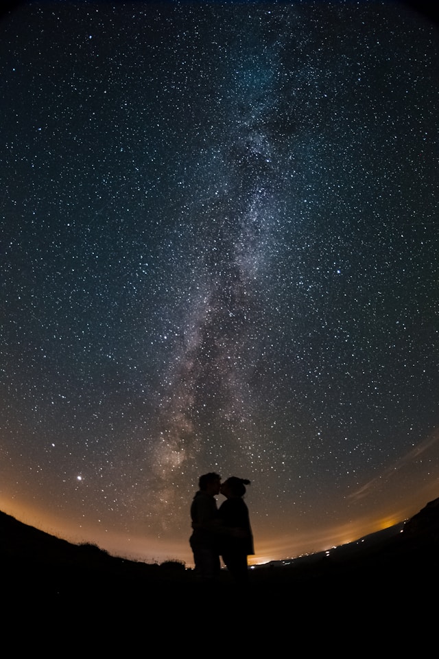 couple stargazing telescope night sky