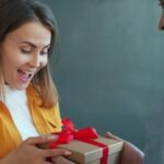 person receiving thoughtful wrapped gift smile