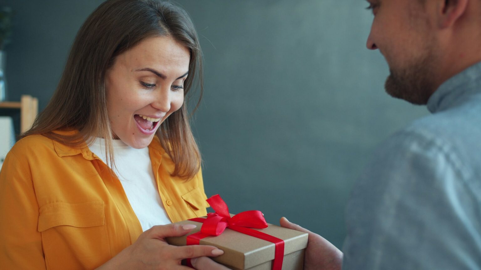 person receiving thoughtful wrapped gift smile