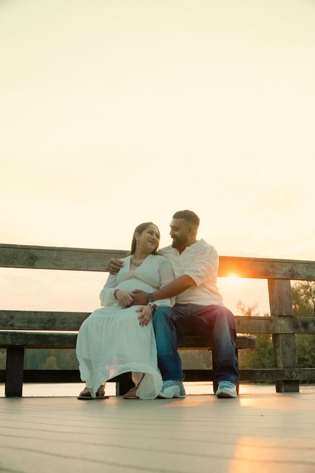 couple sitting bench sunset